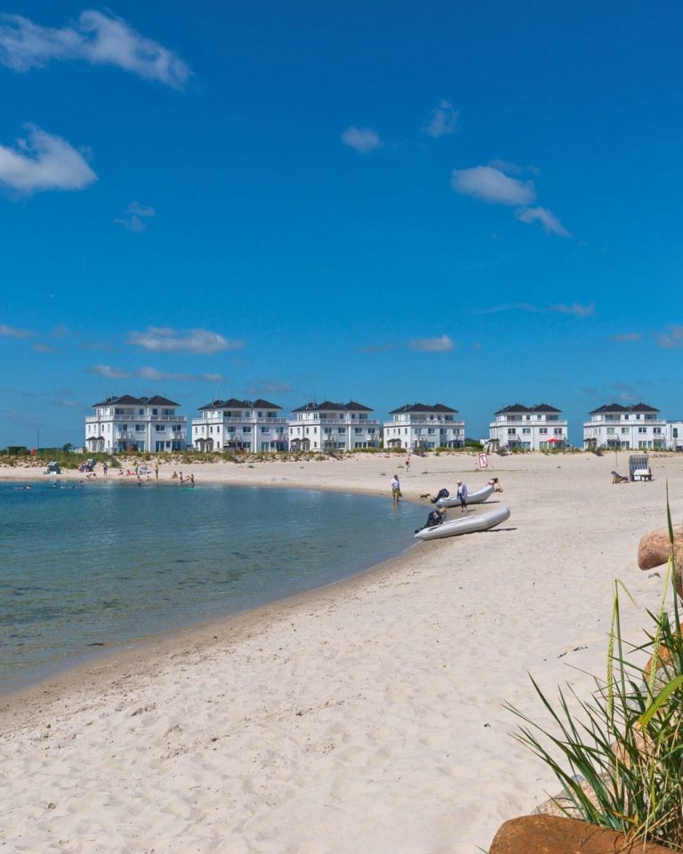 Badebucht im Sommer mit weißem Strand und Personen am Strand