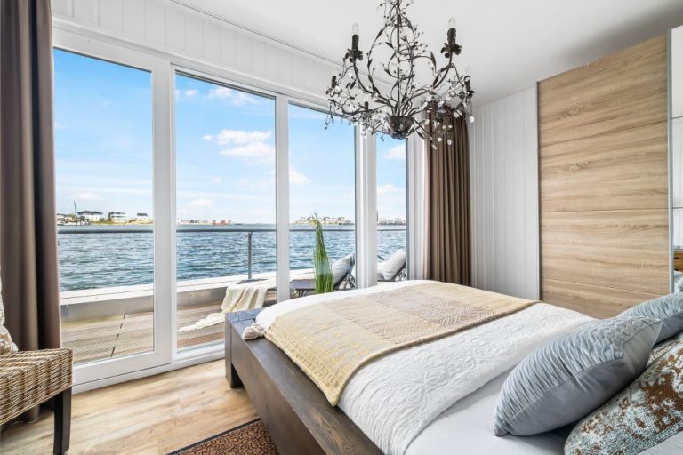 Schlafzimmer mit Fensterfront mit Meerblick