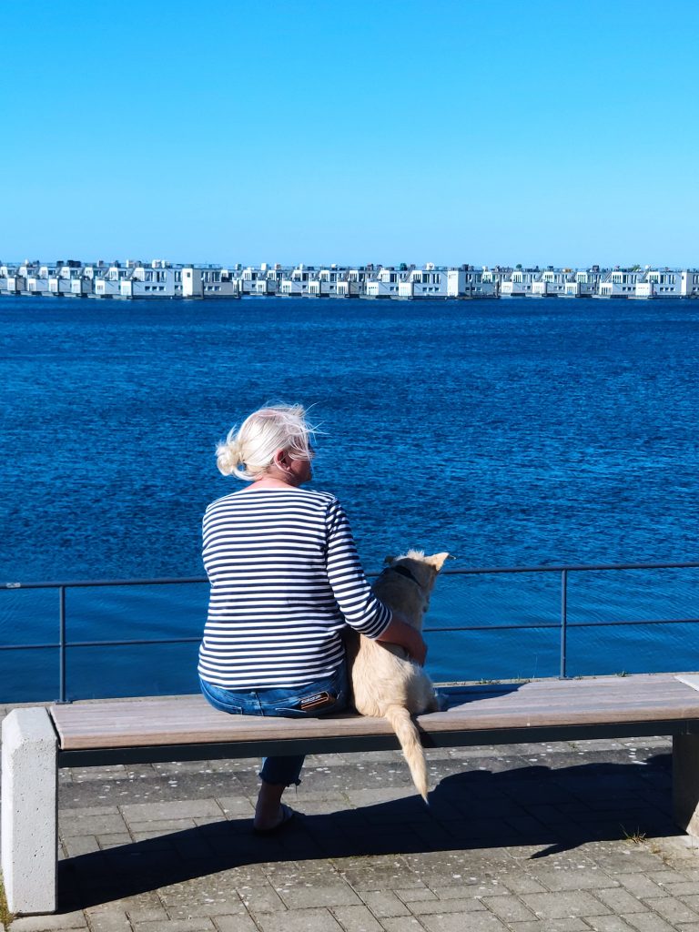 Hafenpromenade Frau mit Hund auf einer Bank