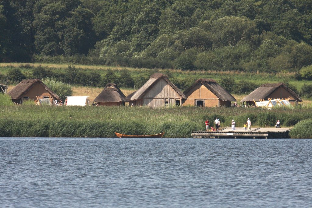 Blick vom Noor zur Landbrücke und zu den rekonstruierten Häusern © Stiftung Schleswig-Holsteinische Landesmuseen
